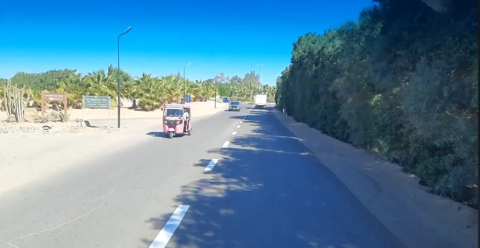 Tuk-tuk on a landscaped internal road inside El Gouna